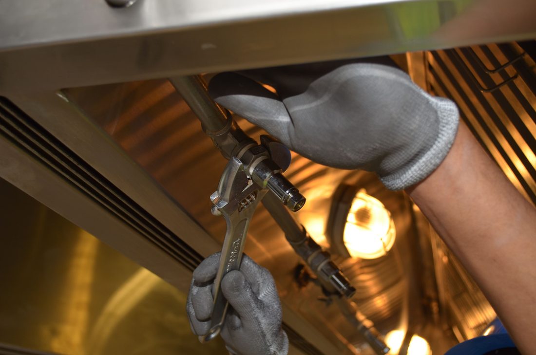 A plumber working on pipework with a wrench