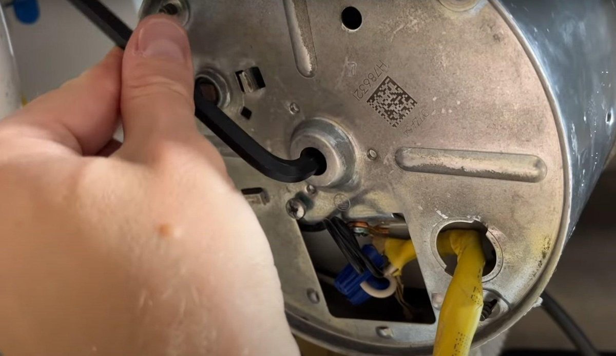 The red reset button on the bottom of a garbage disposal