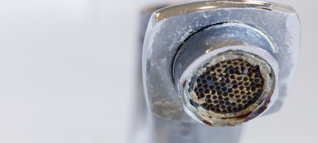 Mineral scale and limescale buildup on a faucet and fixtures