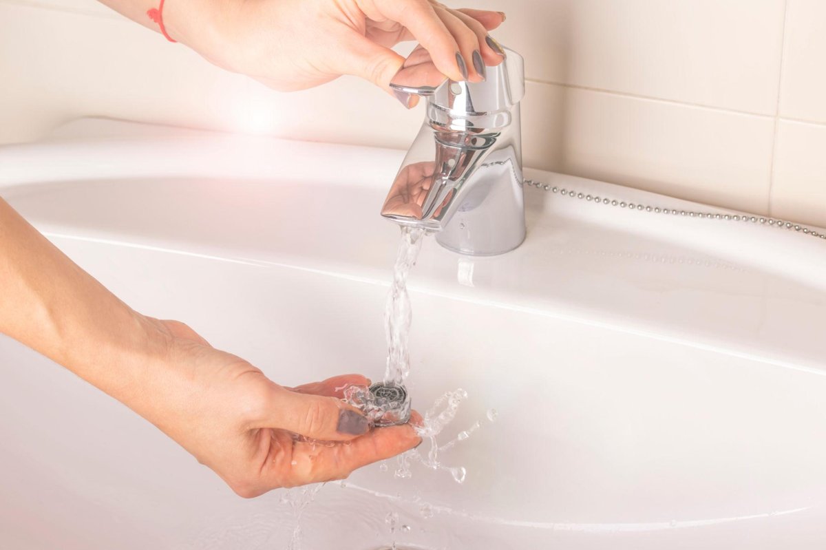 A bathroom faucet running with weak water flow