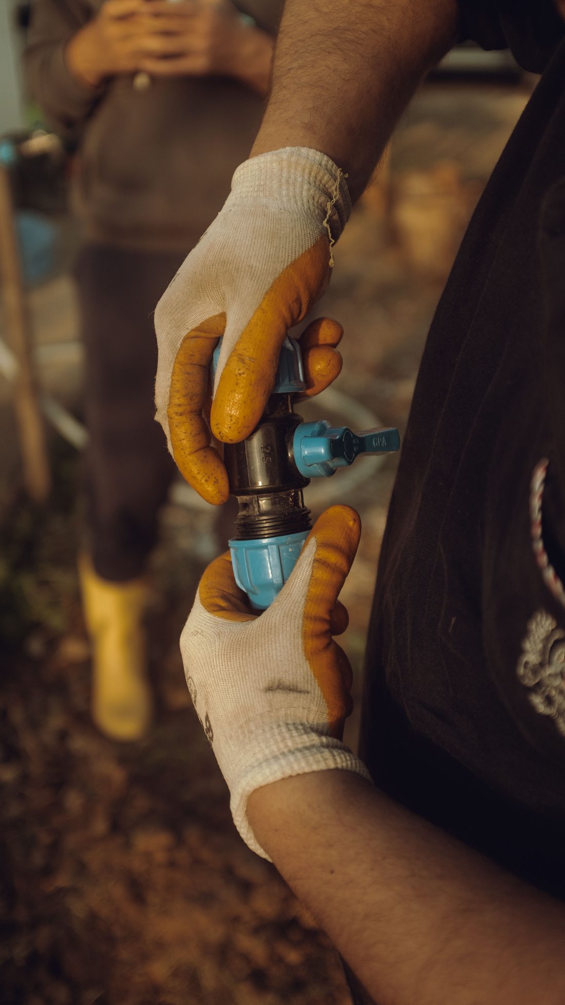Gloved hands joining a pipe fitting